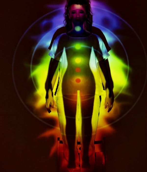 Woman maintaining a difficult yoga balance pose in a dark room.